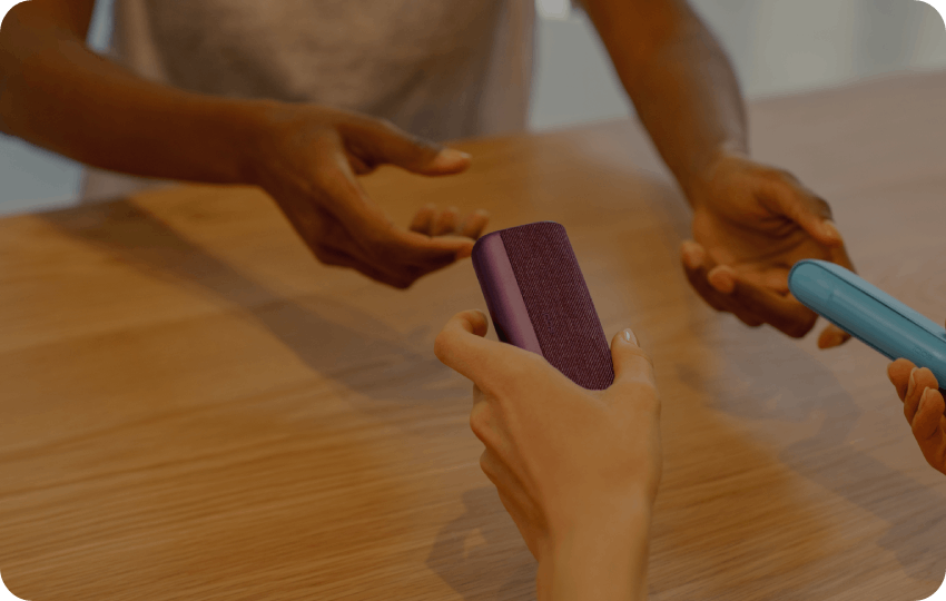 Customers engaging with IQOS products inside a modern retail store environment.