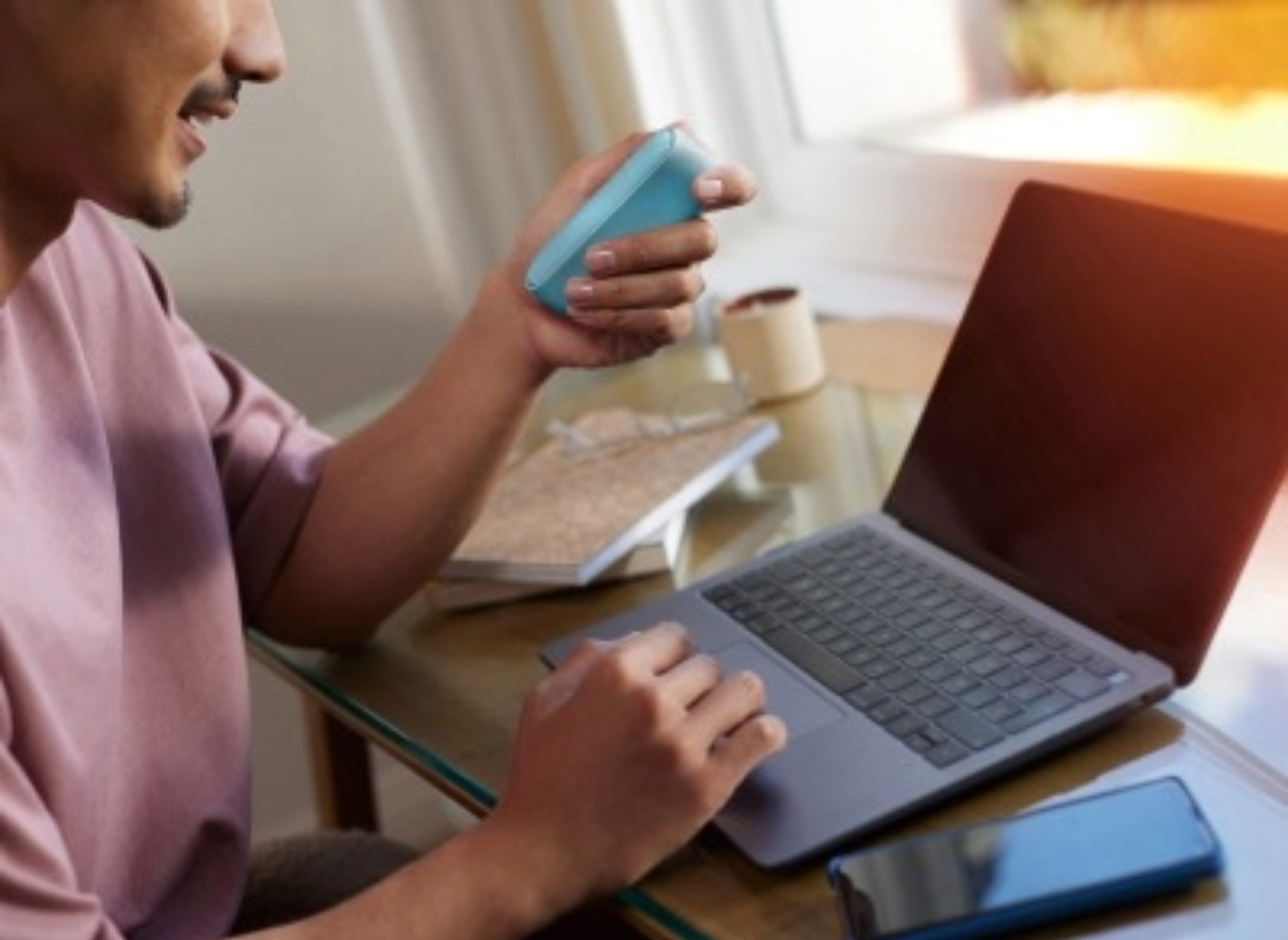 Osoba provádí online diagnostiku na modré kapesní nabíječce IQOS ILUMA