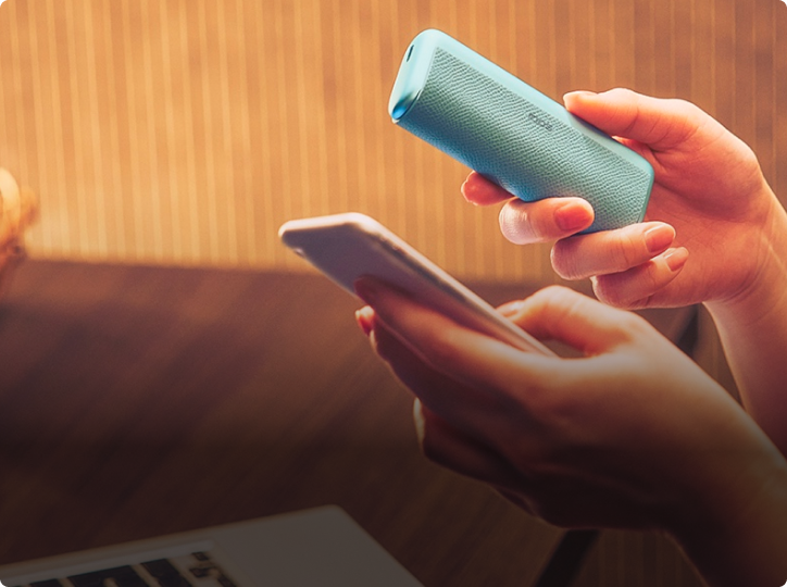 Jemand hält ein IQOS ILUMA i PRIME neben einem Smartphone