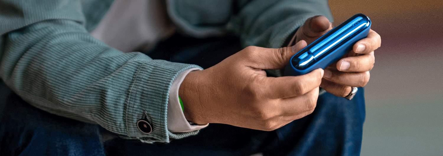 A man holding an IQOS box.