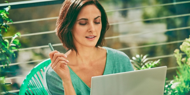 Žena, která drží laptop a zařízení IQOS.