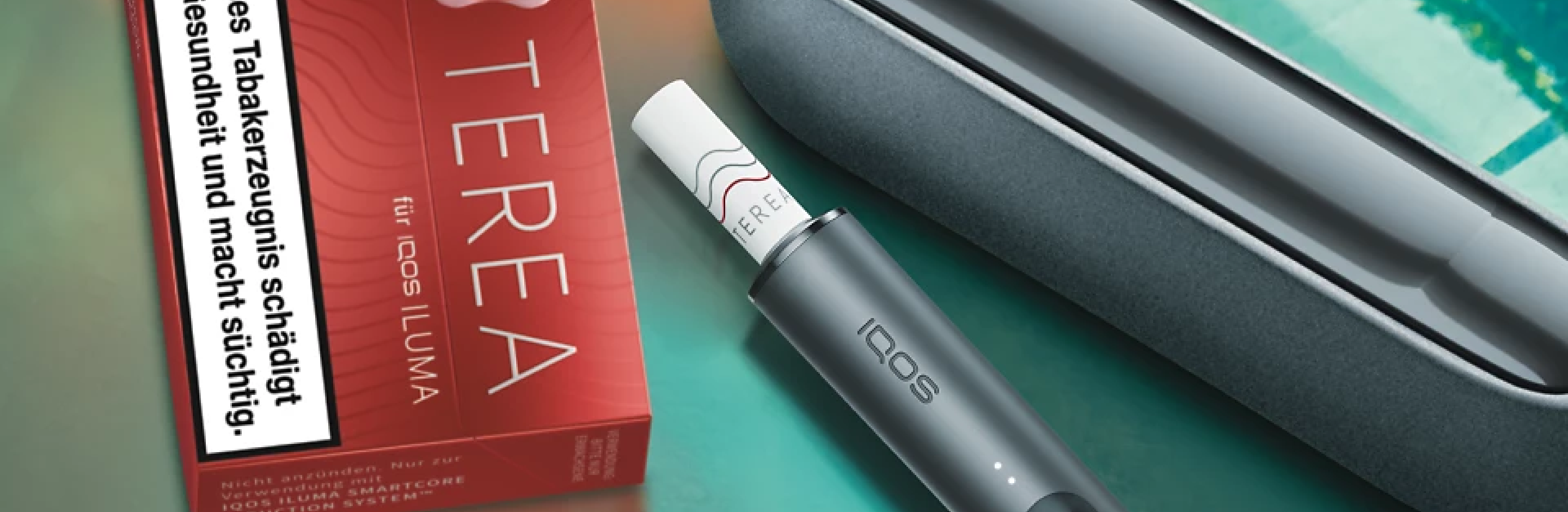 Ein IQOS ILUMA mit Pocketcharger und einer Packung TEREA Tabaksticks auf einer spiegelnden Oberfläche