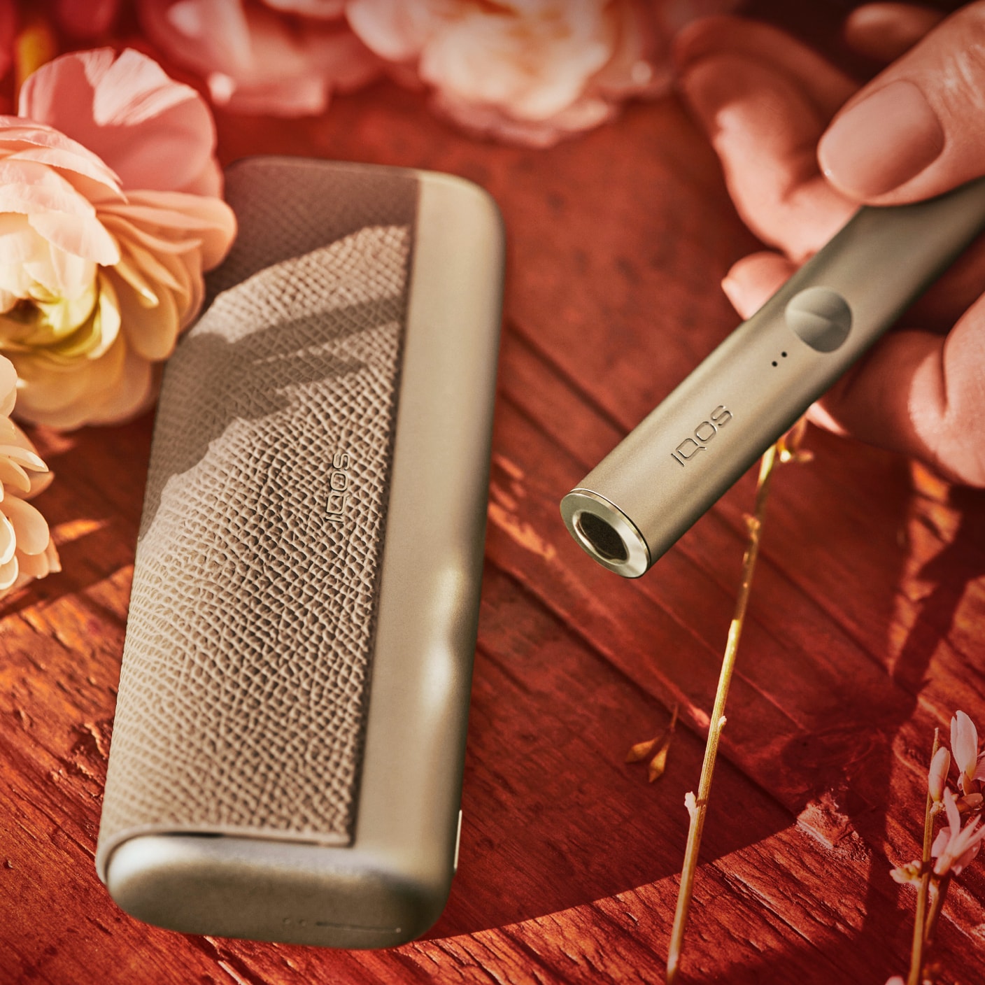 Brilliant gold IQOS 3 DUO holder with HEETS stick on charger on red fabric