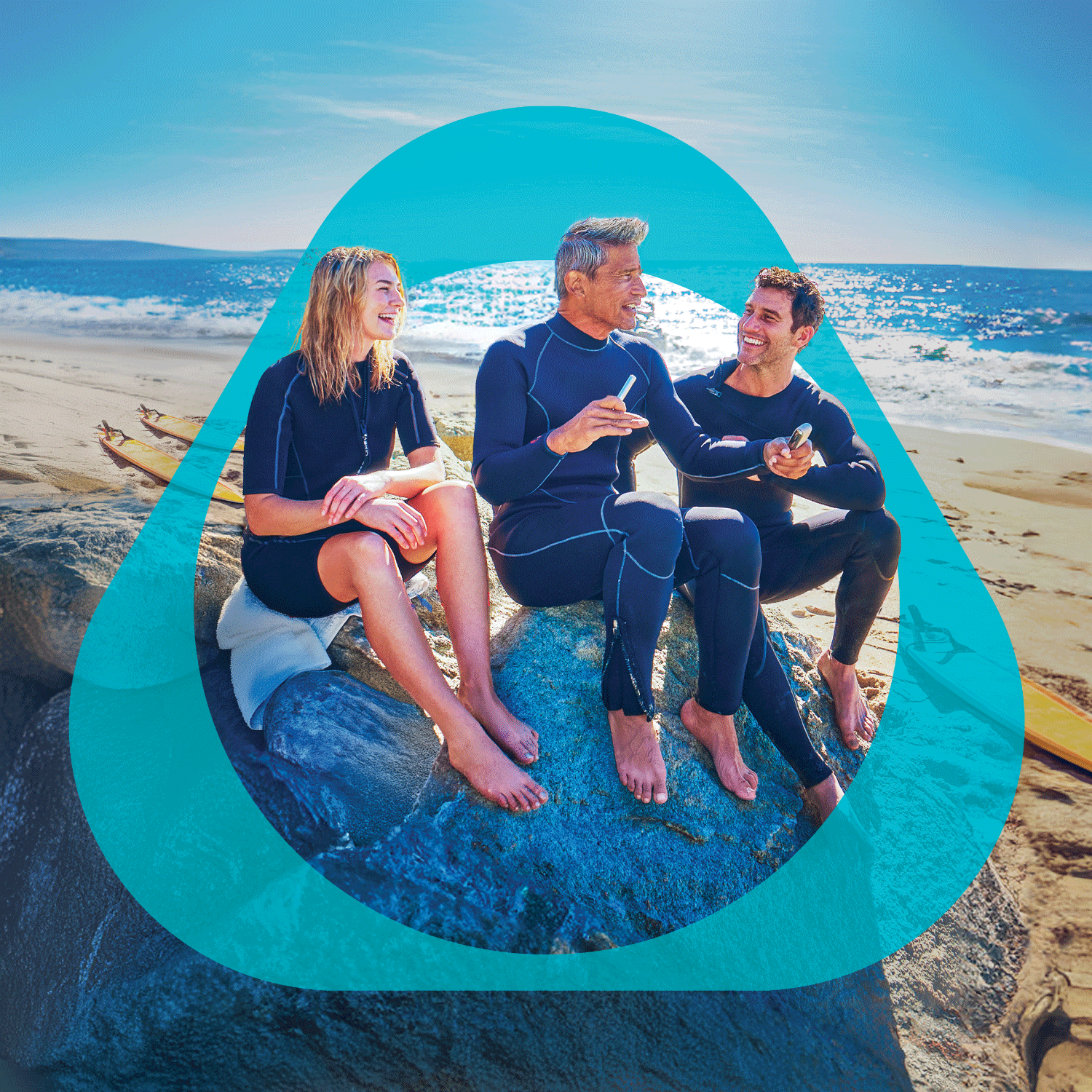 Three people sitting outdoors on a beach, having a conversation while holding IQOS ILUMA i.